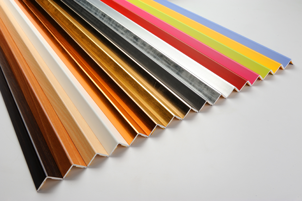 A variety of aluminum profiles in different colors and finishes arranged in a row, showcasing options for enhancing ceramic tile installations.