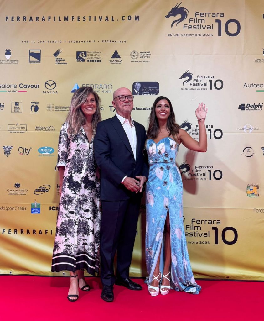 Three individuals posing on the red carpet at the Ferrara Film Festival, with a backdrop celebrating its tenth anniversary.
